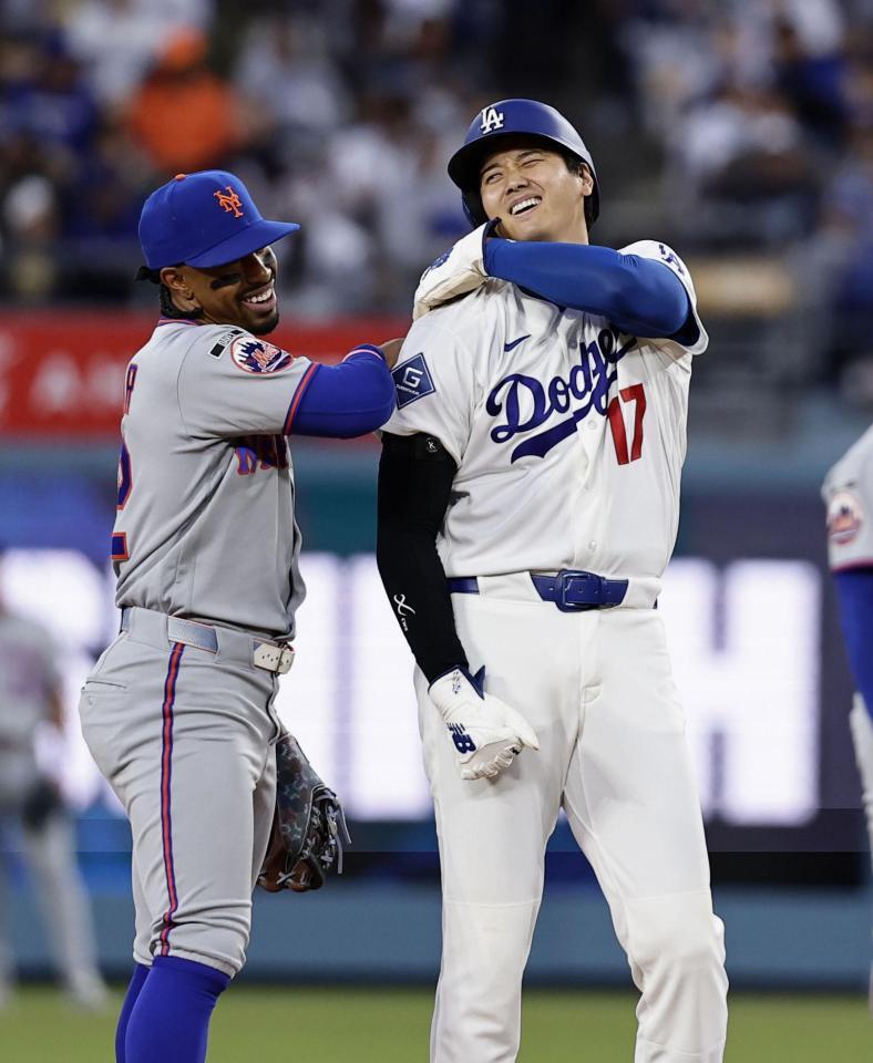 メッツ戦の１回、死球で出塁し後続の四球で二進し、遊撃手リンドア（左）と話す大谷＝ロサンゼルス（共同）