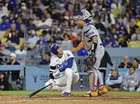 メッツ戦の６回、捕手アルバレスの一塁へのけん制球が当たりそうになり、笑顔を見せる大谷＝ロサンゼルス（共同）