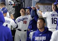 　メッツ戦の７回を投げ終え、ベンチでタッチを交わすドジャース・山本（共同）