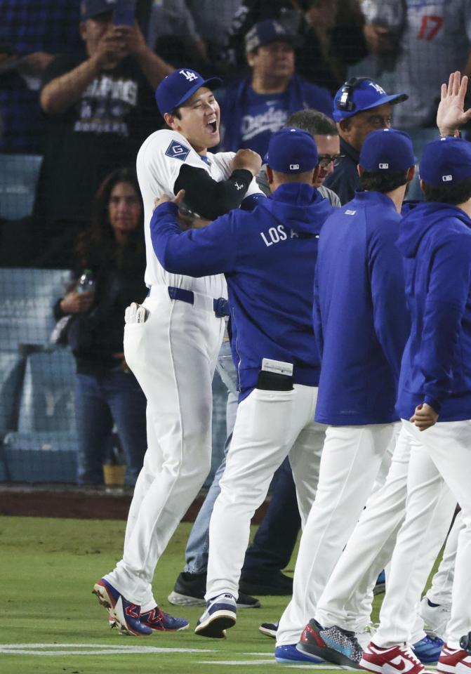 メッツに勝利し、ロバーツ監督（手前）に迎えられる大谷＝ロサンゼルス（共同）