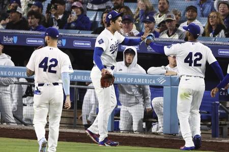 ５回を投げ終え、Ｔ・ヘルナンデス（右）とタッチする大谷（共同）