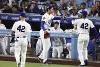 ５回を投げ終え、Ｔ・ヘルナンデス（右）とタッチする大谷（共同）