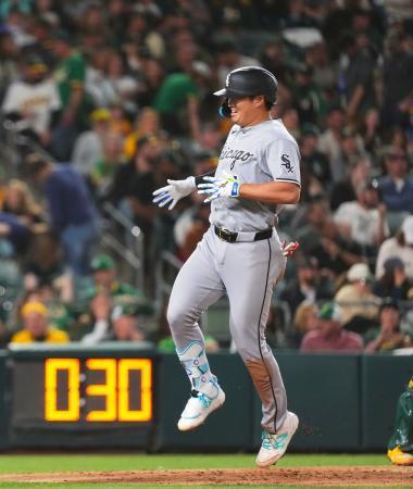 　アスレチックス戦の７回、メジャー移籍後初の満塁本塁打を放ち、チームメートに迎えられるホワイトソックス・村上＝サクラメント（共同）