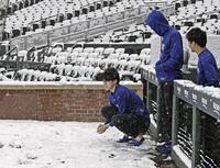 　雪が積もったクアーズ・フィールドを見つめるドジャース・佐々木（左）＝デンバー（共同）
