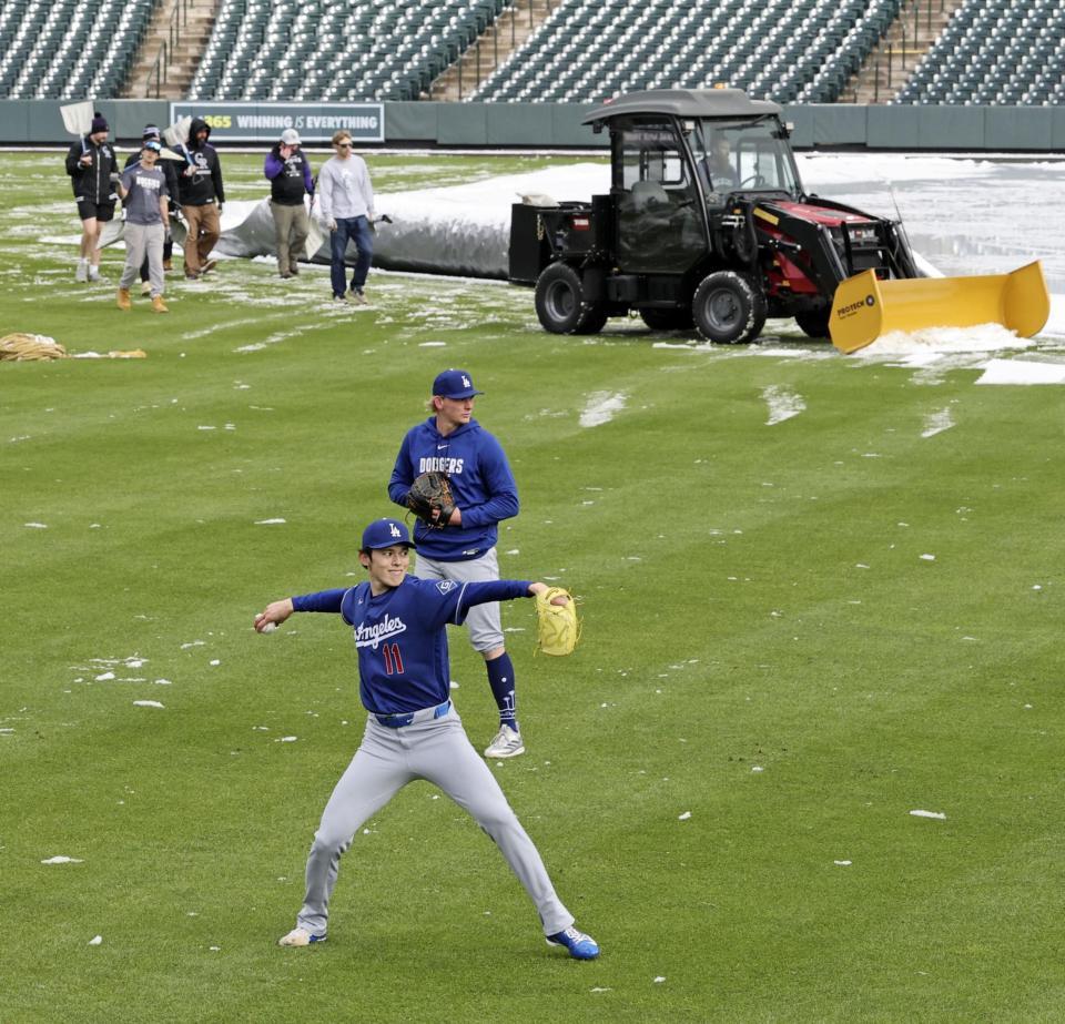 　除雪作業が行われる中、キャッチボールするドジャース・佐々木（手前）＝デンバー（共同）