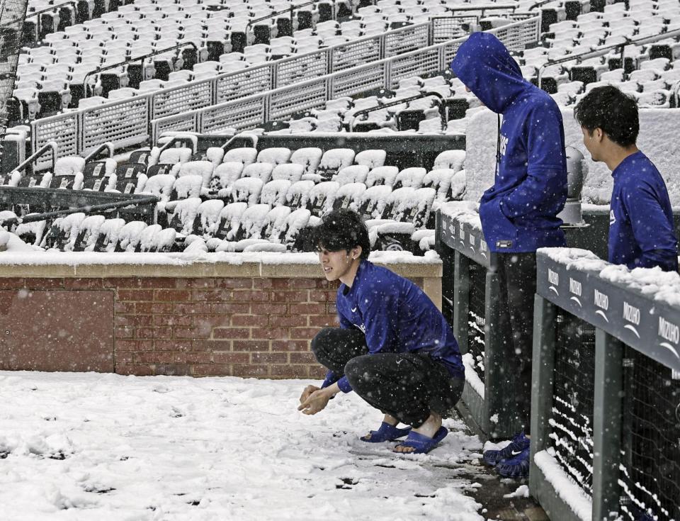 　雪が積もったクアーズ・フィールドを見つめるドジャース・佐々木（左）＝デンバー（共同）