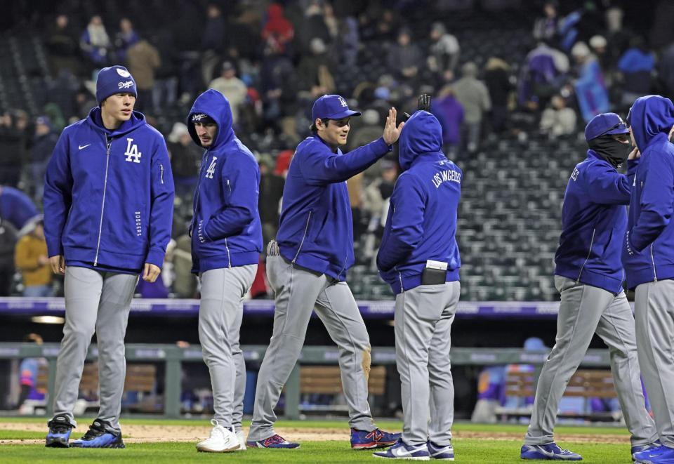　ロッキーズに勝利し、タッチを交わすドジャース・大谷（左から３人目）。左端は佐々木＝デンバー（共同）