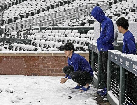 　雪が積もったクアーズ・フィールドを見つめる佐々木（左）＝共同　