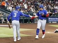　ダイヤモンドバックス戦の３回、３号ソロを放ち迎えられるブルージェイズ・岡本（右）＝フェニックス（共同）
