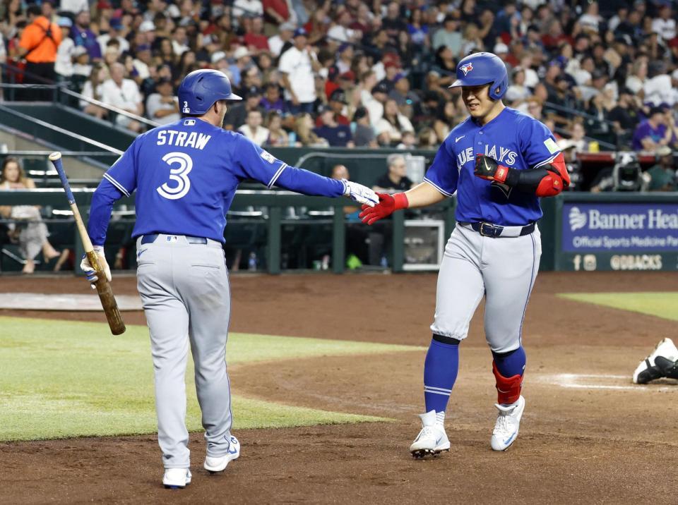 　ダイヤモンドバックス戦の３回、３号ソロを放ち迎えられるブルージェイズ・岡本（右）＝フェニックス（共同）