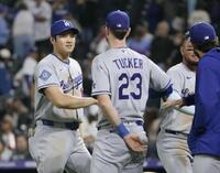 　ロッキーズに勝利し、チームメートとタッチを交わす大谷（左端）＝共同