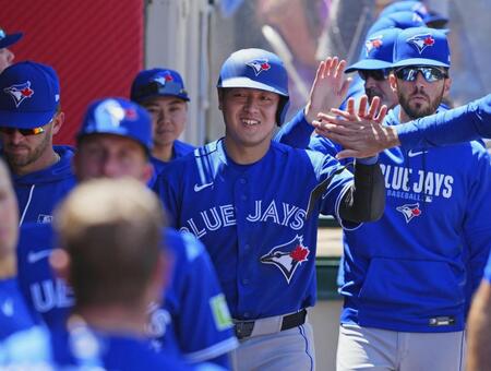 　エンゼルス戦の７回、後続の内野ゴロの間に生還し、迎えられるブルージェイズの三走岡本＝アナハイム（共同）