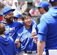 　試合前に、チームメートと談笑するブルージェイズ・岡本＝アナハイム（共同）
