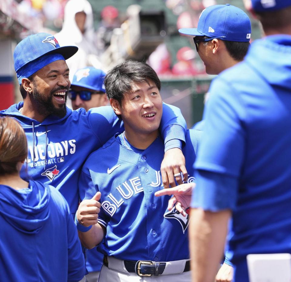 　試合前に、チームメートと談笑するブルージェイズ・岡本＝アナハイム（共同）