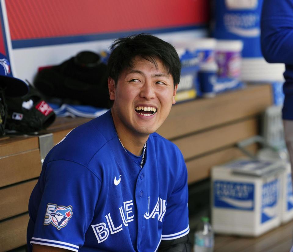 　試合前に、チームメートと笑顔で話すブルージェイズ・岡本＝アナハイム（共同）