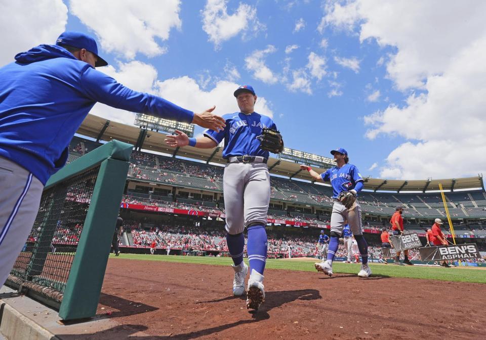 　エンゼルス戦で、２回の守備を終えてベンチに戻るブルージェイズ・岡本＝アナハイム（共同）