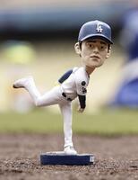 　来場者に配られた佐々木の首振り人形（共同）