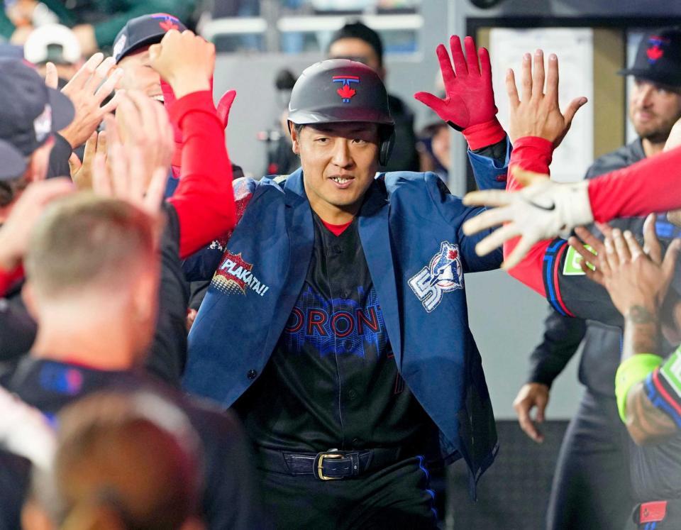 　２回、ソロを放ち、ベンチで迎えられる岡本（共同）