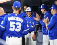 ガーディアンズ戦の試合前、ベンチで笑顔を見せる岡本（共同）