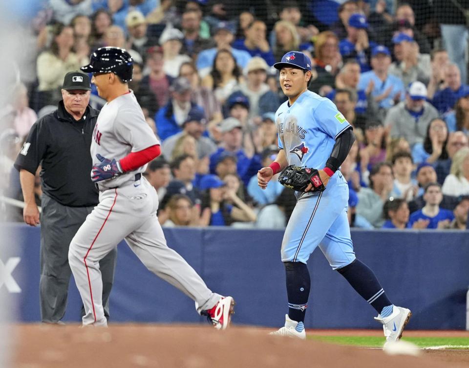 　４回、残塁に終わった一走・吉田（左）と、表情を緩める岡本＝トロント（共同）