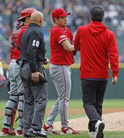 ３回のイニング間の投球練習中に左肩の張りを訴えて降板する菊池（共同）