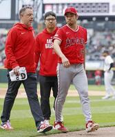 ３回のイニング間の投球練習中に左肩の張りを訴えて降板する菊池（共同）