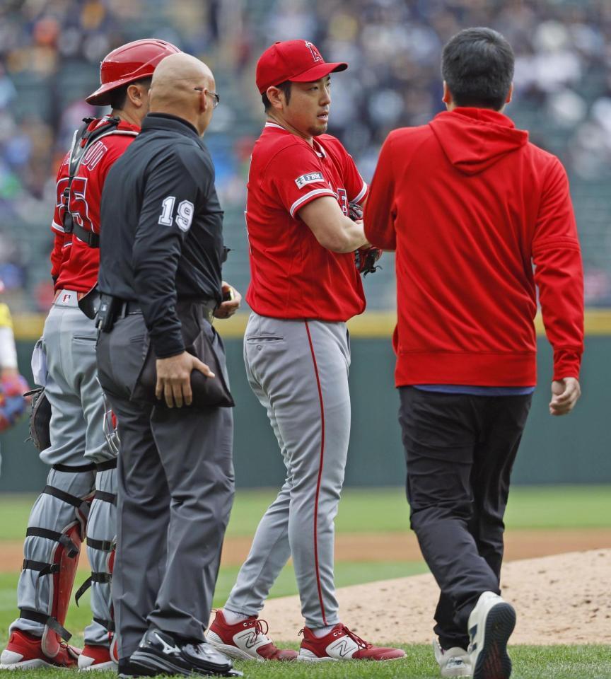 ３回のイニング間の投球練習中に左肩の張りを訴えて降板する菊池（共同）