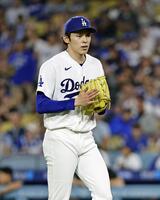 　ジャイアンツ戦の４回を投げ終え、グラブをたたきながらベンチに戻るドジャース・佐々木＝ロサンゼルス（共同）