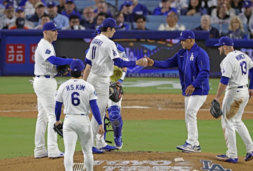 　ジャイアンツ戦の６回途中、降板するドジャース・佐々木。右から２人目はロバーツ監督＝ロサンゼルス（共同）