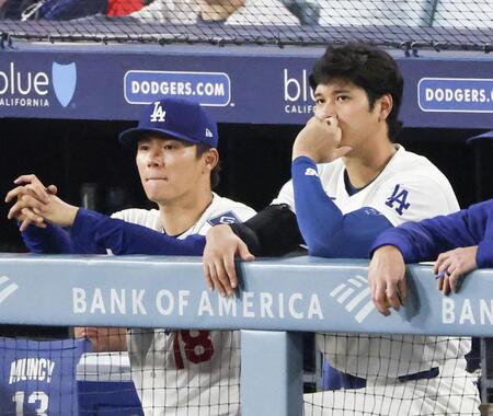 　ジャイアンツ戦の７回、ベンチから試合を見つめる山本（左）と大谷（共同）