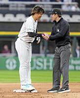 　ロイヤルズ戦の３回、後続の四球で二進し塁審に握手であいさつする一走村上（共同）