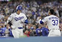 　ジャイアンツ戦の３回、７号ソロを放ち、Ｔ・ヘルナンデス（右）に迎えられる大谷（共同）