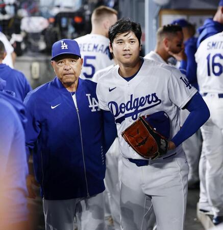 　ジャイアンツ戦の７回を投げ終えベンチに戻ったドジャース・大谷。左はロバーツ監督＝ロサンゼルス（共同）