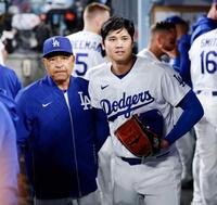 　７回を投げ終えベンチに戻った大谷。左はロバーツ監督（共同）