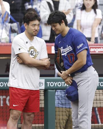試合前に談笑する菊池（左）と大谷（共同）