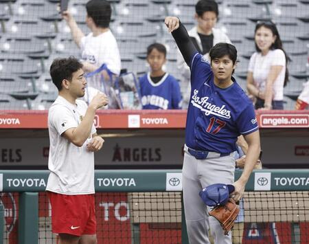 試合前に談笑する菊池（左）と大谷（共同）