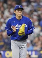 ５回を投げ終え、グラブをたたく佐々木（共同）