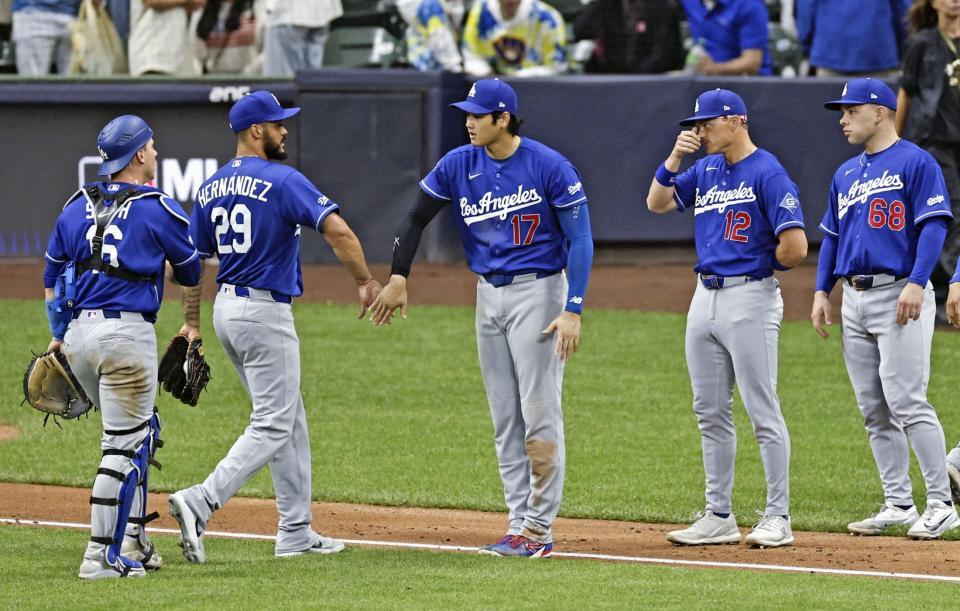 勝利し、タッチを交わす大谷（中央）＝共同