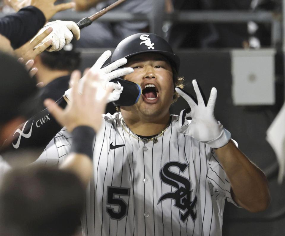 ８回、１９号２ランを放ち、ベンチで迎えられる村上（共同）
