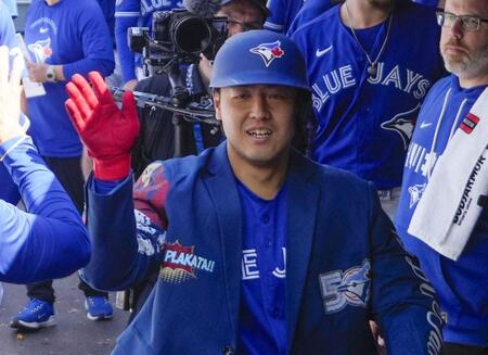 　マーリンズ戦の６回、勝ち越しの11号ソロを放ち、ベンチで迎えられるブルージェイズ・岡本＝トロント（ロイター＝共同）
