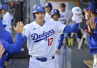 　ロッキーズ戦の１回、９号となる先頭打者本塁打を放ち、ベンチで迎えられるドジャース・大谷＝ロサンゼルス（ロイター＝共同）
