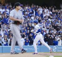 　ロッキーズ戦の１回、菅野（手前）から先頭打者本塁打を放ち、塁を回るドジャース・大谷＝ロサンゼルス（共同）