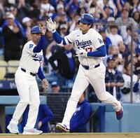 　ロッキーズ戦の１回、先頭打者本塁打を放ち、コーチとタッチを交わすドジャース・大谷＝ロサンゼルス（共同）