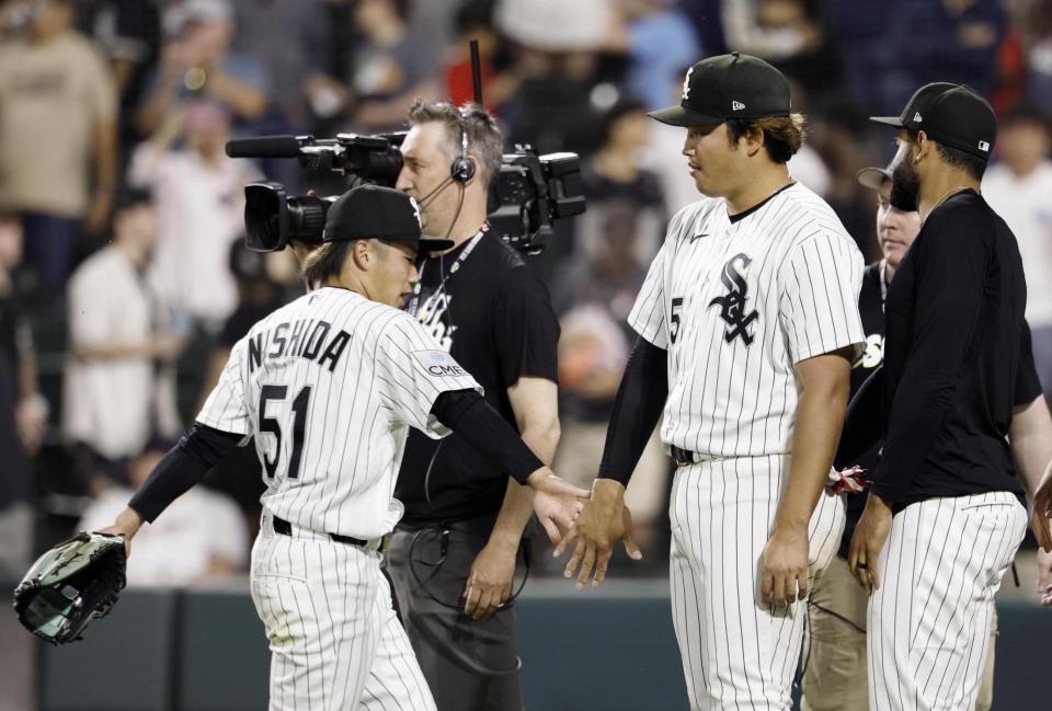 　ツインズに勝利し、西田（51）とタッチを交わすホワイトソックス・村上＝シカゴ（共同）