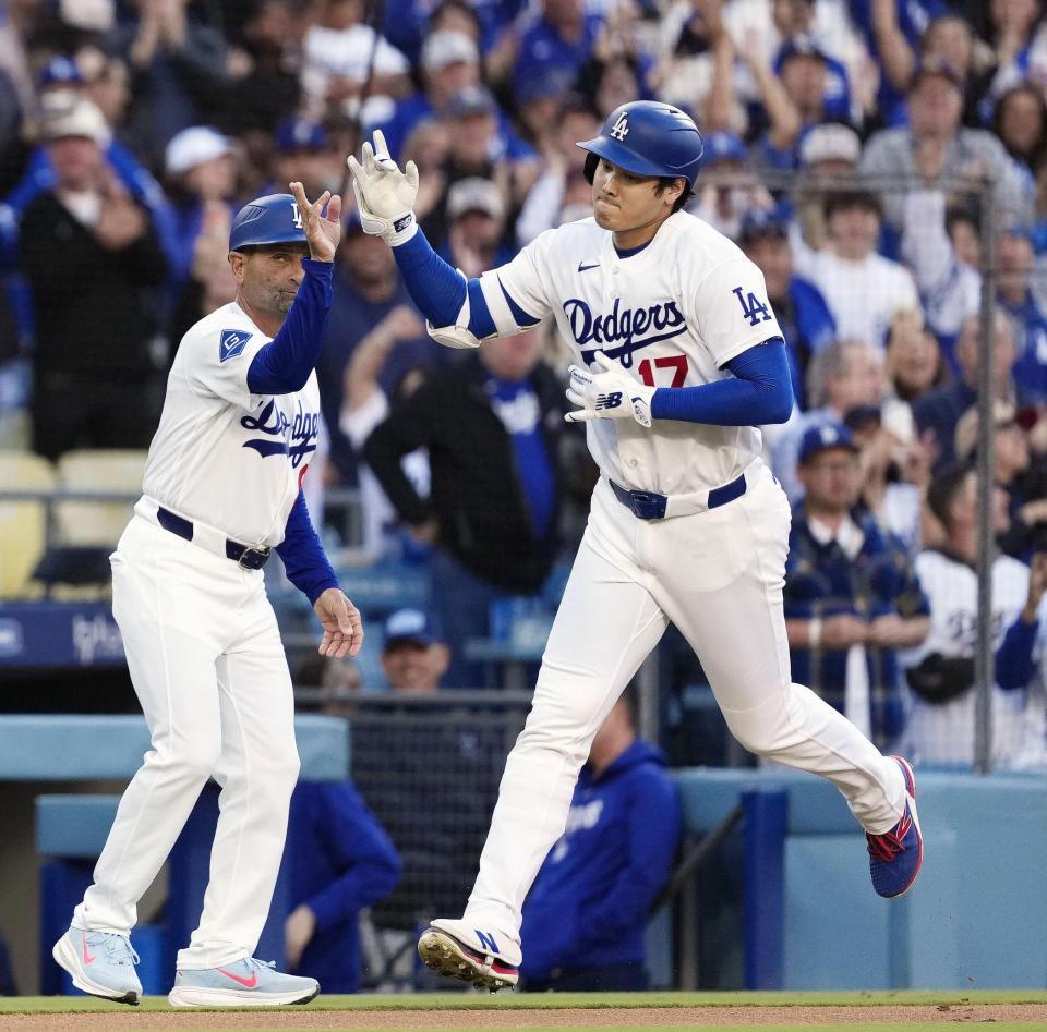 　ロッキーズ戦の１回、先頭打者本塁打を放ち、コーチとタッチを交わすドジャース・大谷＝ロサンゼルス（共同）