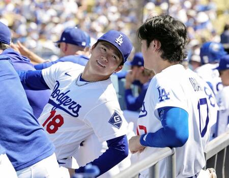 　フィリーズ戦の６回途中で降板し、ベンチで大谷（右）と言葉を交わすドジャース・山本＝ロサンゼルス（共同）