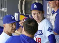 　フィリーズ戦の６回途中で降板し、ベンチでロバーツ監督（左）と話すドジャース・山本＝ロサンゼルス（共同）