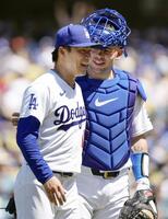 　フィリーズ戦の５回、２死二、三塁のピンチを切り抜け、捕手ラッシング（右）と笑顔でベンチに戻るドジャース・山本＝ロサンゼルス（共同）