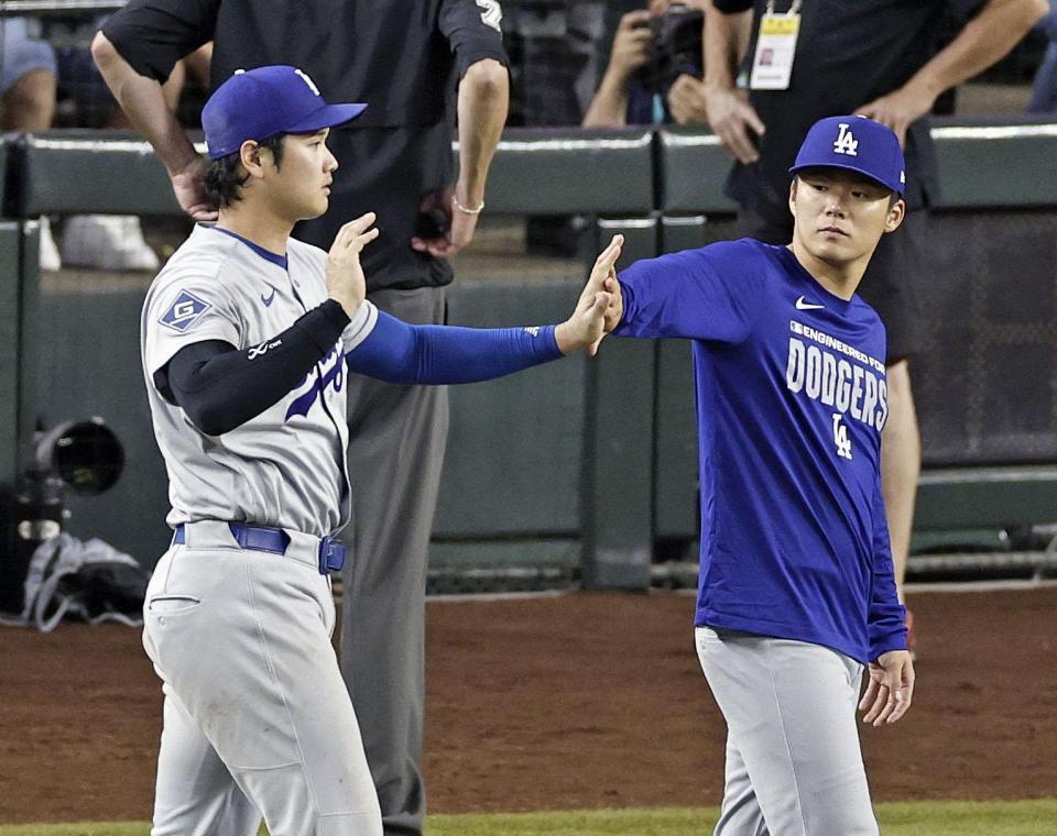 ダイヤモンドバックスに勝利し、タッチを交わす大谷（左）と山本（共同）