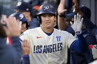 　エンゼルス戦の１回、この回２度目の打席で11号２ランを放ち、ベンチで迎えられるドジャース・大谷＝ロサンゼルス（ゲッティ＝共同）